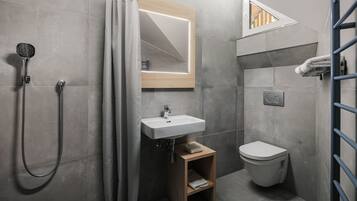 A modern bathroom with a shower, toilet, and sink.