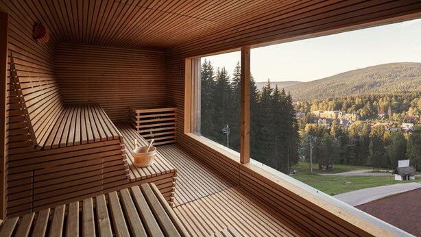 A wooden interior with a large window overlooking a forested area. - Ski & Spa Bellevue Harrachov (Harrachov)