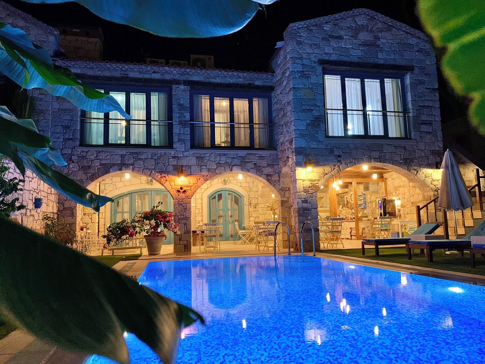 Una piscina al aire libre, sombrillas, sillones reclinables de piscina