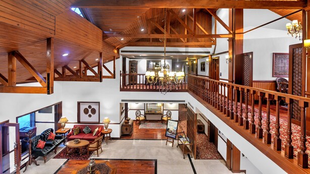 A spacious interior with high ceilings, wooden beams, a grand staircase, and a chandelier. - Fortune Resort Heevan, Srinagar - Member ITC Hotels' Group (Srinagar)