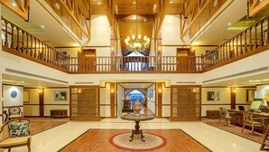 A spacious lobby with a grand chandelier, wooden flooring, and a central decorative piece. - Fortune Resort Heevan, Srinagar - Member ITC Hotels' Group (Srinagar)
