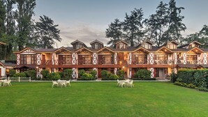 A traditional chalet-style hotel with multiple balconies, a well-maintained lawn, and outdoor seating areas. - Fortune Resort Heevan, Srinagar - Member ITC Hotels' Group (Srinagar)