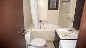 Un bagno con WC, vasca e lavandino.