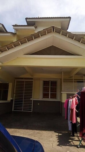 A residential building with a sloped roof, large windows with horizontal blinds, and a clothesline with garments. - Nadrah Putrajaya Homestay (Putrajaya)