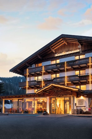 Et hotel med en træfacade, flere balkoner og lyskæder.