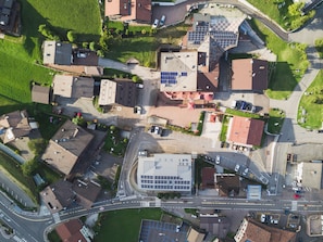 Oversigtsbillede af et boligområde med flere huse, en parkeringsplads og et vejkryds.