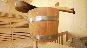 Un barril de madera con una banda metálica y un asa de madera, probablemente utilizado para almacenamiento o como recipiente.