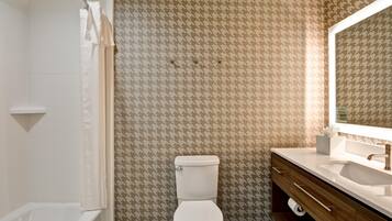 Un baño con pared estampada, inodoro, lavabo y espejo.