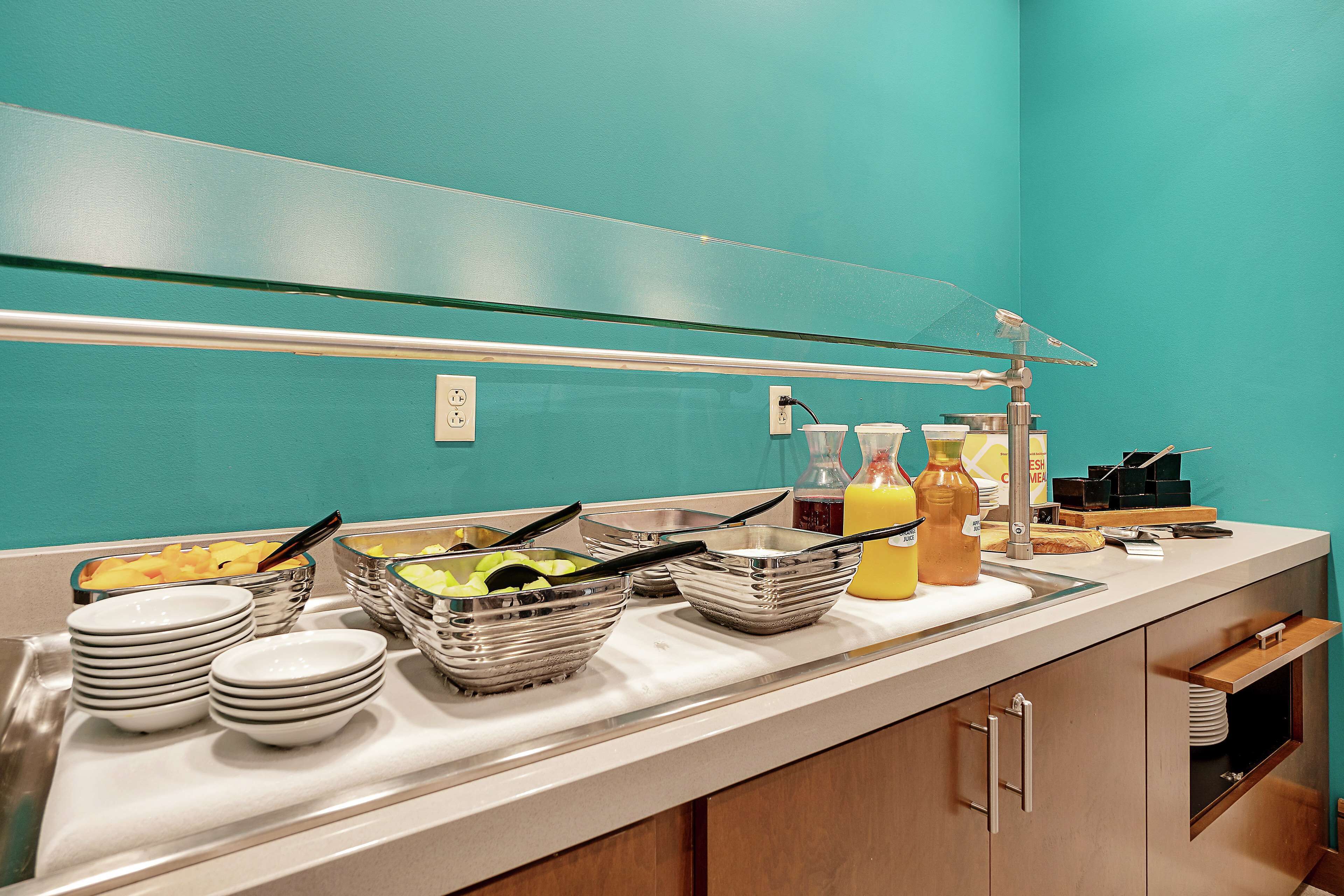 A buffet setup with various food items and serving utensils.