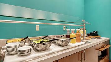 Una barra de buffet con diferentes alimentos y utensilios para servir.