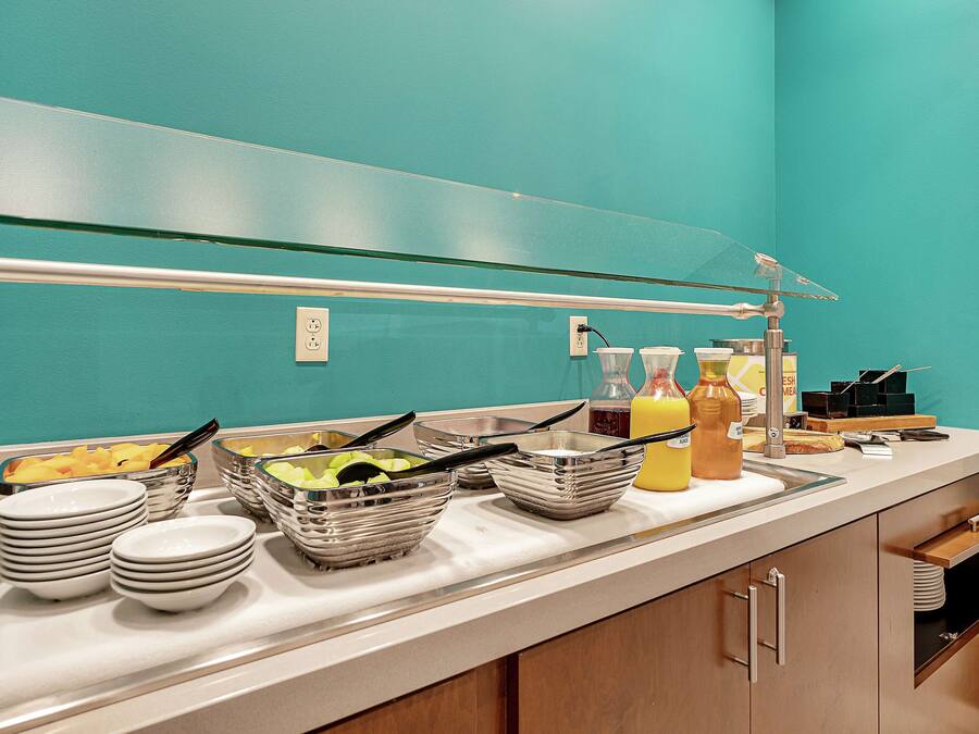 Una barra de buffet con diferentes alimentos y utensilios para servir.