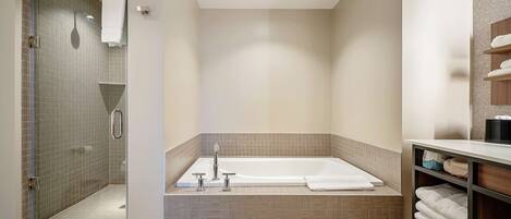A modern bathroom with a walk-in shower, a freestanding bathtub, and a vanity with shelves.