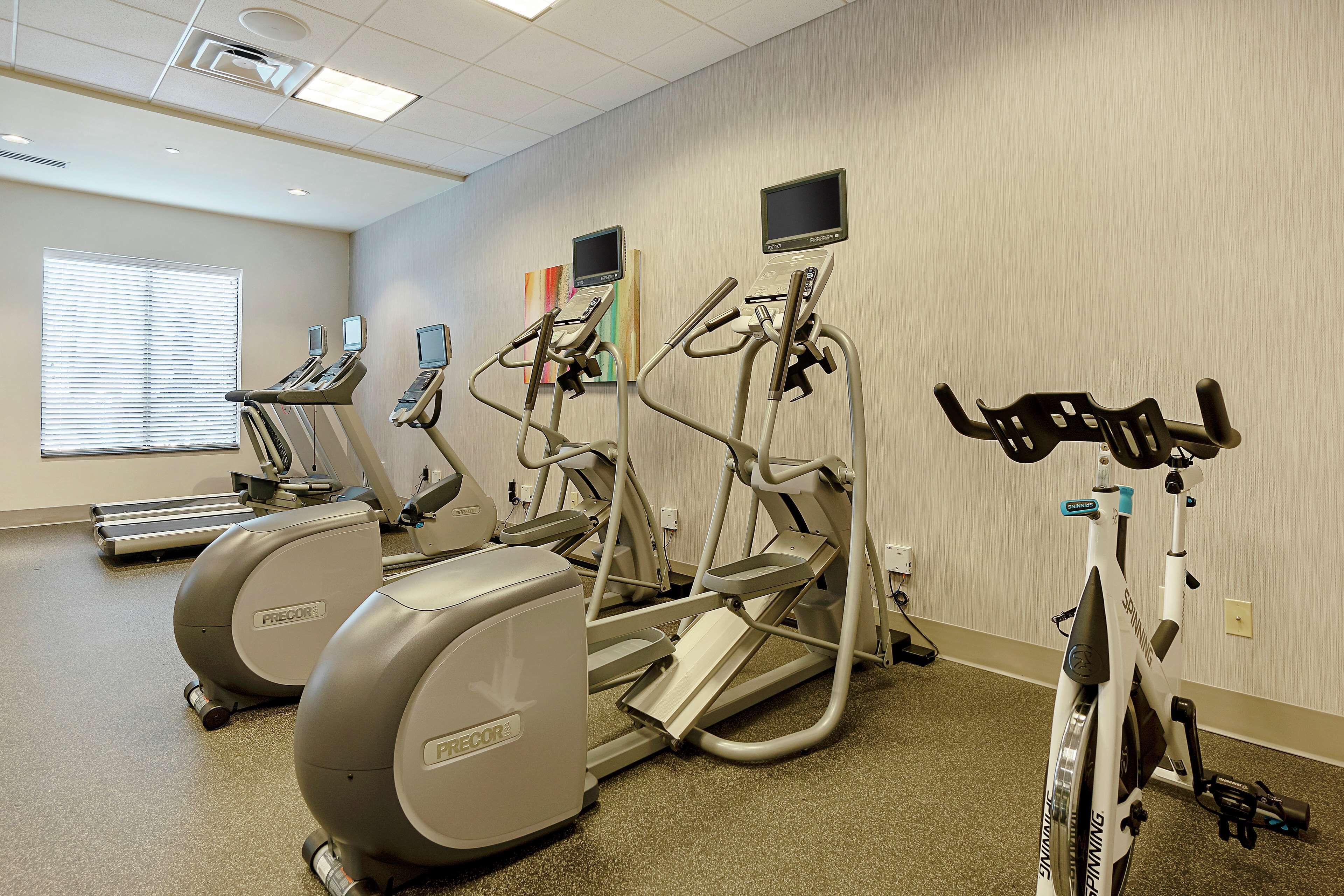 A fitness center with treadmills, elliptical machines, and stationary bikes.
