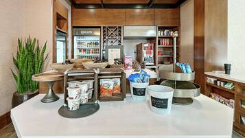 A coffee shop interior with a counter displaying coffee cups, a plant, and various coffee-related items.