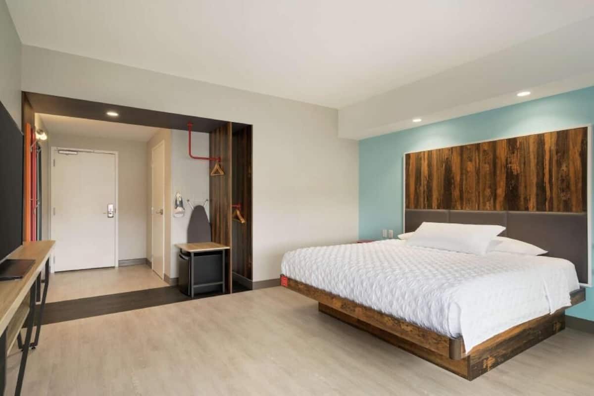 A bedroom with a bed, a desk, a chair, and a wardrobe.