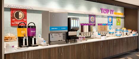 A coffee and donut station with decaf and regular options, a yogurt and cereal bar, and a top it breakfast section.