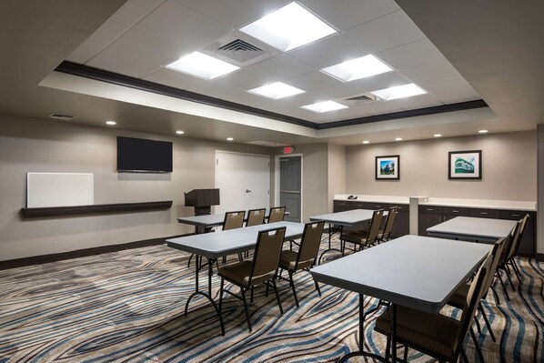 A conference room with tables and chairs, a whiteboard, and framed pictures on the walls. - Hampton Inn & Suites West Melbourne-Palm Bay Road (Melbourne)