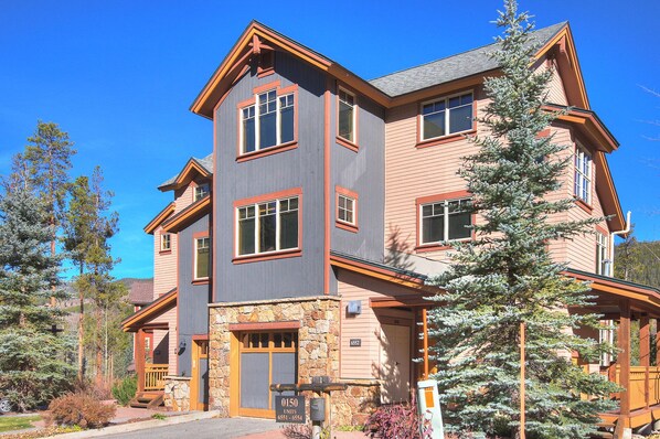 A multi-story building with a stone foundation, large windows, and a mix of brick and siding exteriors. - Settlers Creek (Keystone)