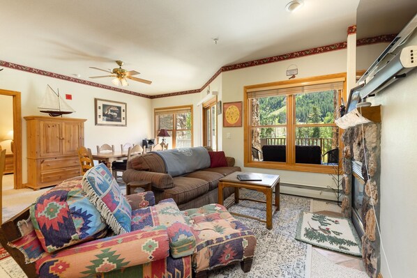 A cozy living room with a sofa, ottoman, and a wooden cabinet. - 5949 Hidden River Lodge 3 Bedroom Condo by RedAwning (Keystone)