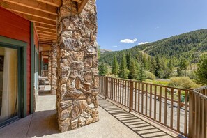 A stone pillar with a wooden balcony railing overlooking a mountainous landscape. - 5949 Hidden River Lodge 3 Bedroom Condo by RedAwning (Keystone)