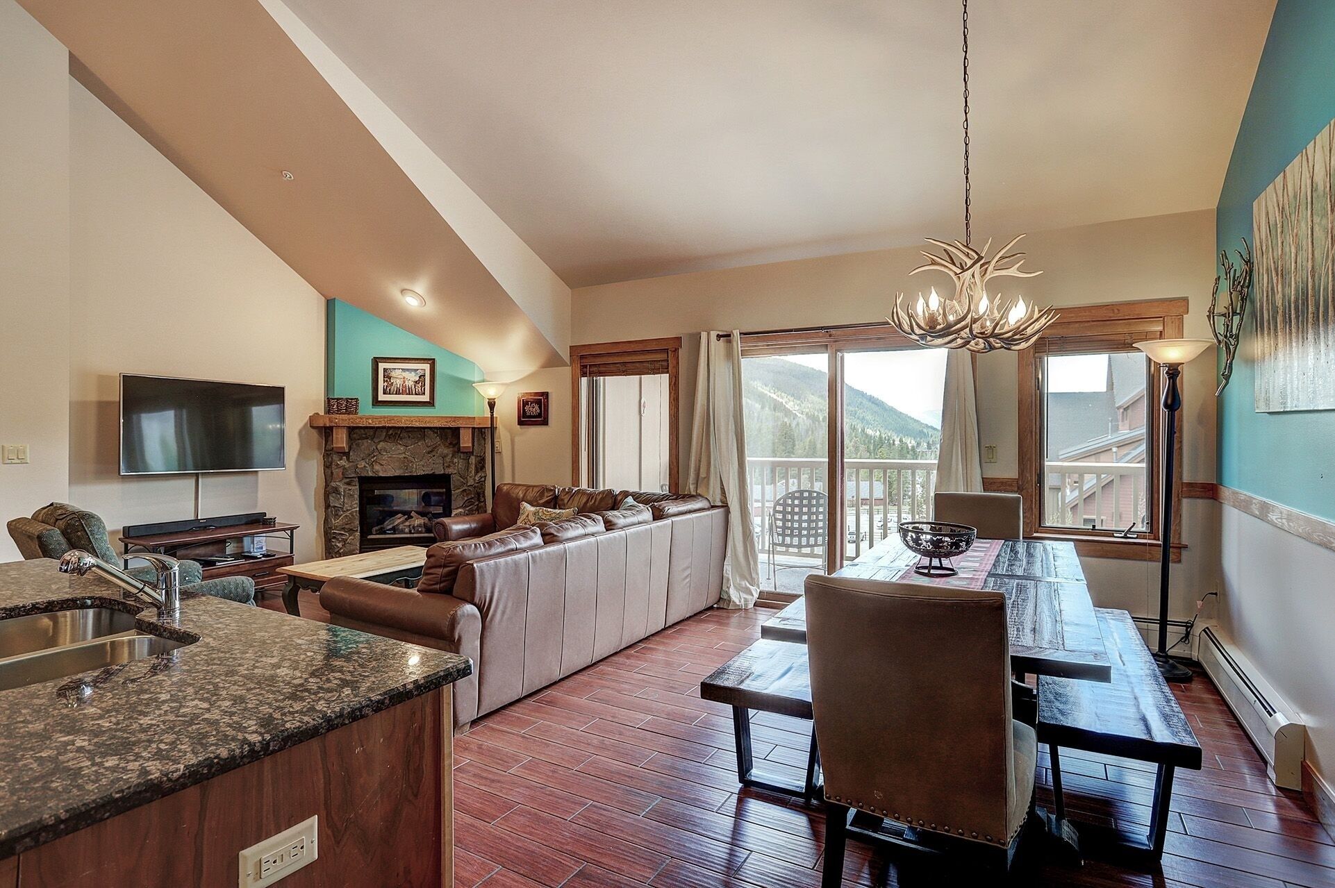 A spacious living area with a fireplace, a dining table, and a kitchen area with a granite countertop.