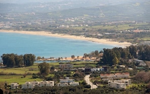 A coastal town with a beach, residential buildings, and a clear view of the sea.