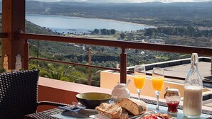 A table with breakfast items, a view of a lake, and a mountainous landscape. - Daphne-Morfi Village (Apokoronas)