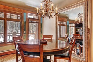 A dining room with a round wooden table, chairs, and a chandelier. - 3044 Lone Eagle 2 Bedroom Condo by RedAwning (Keystone)