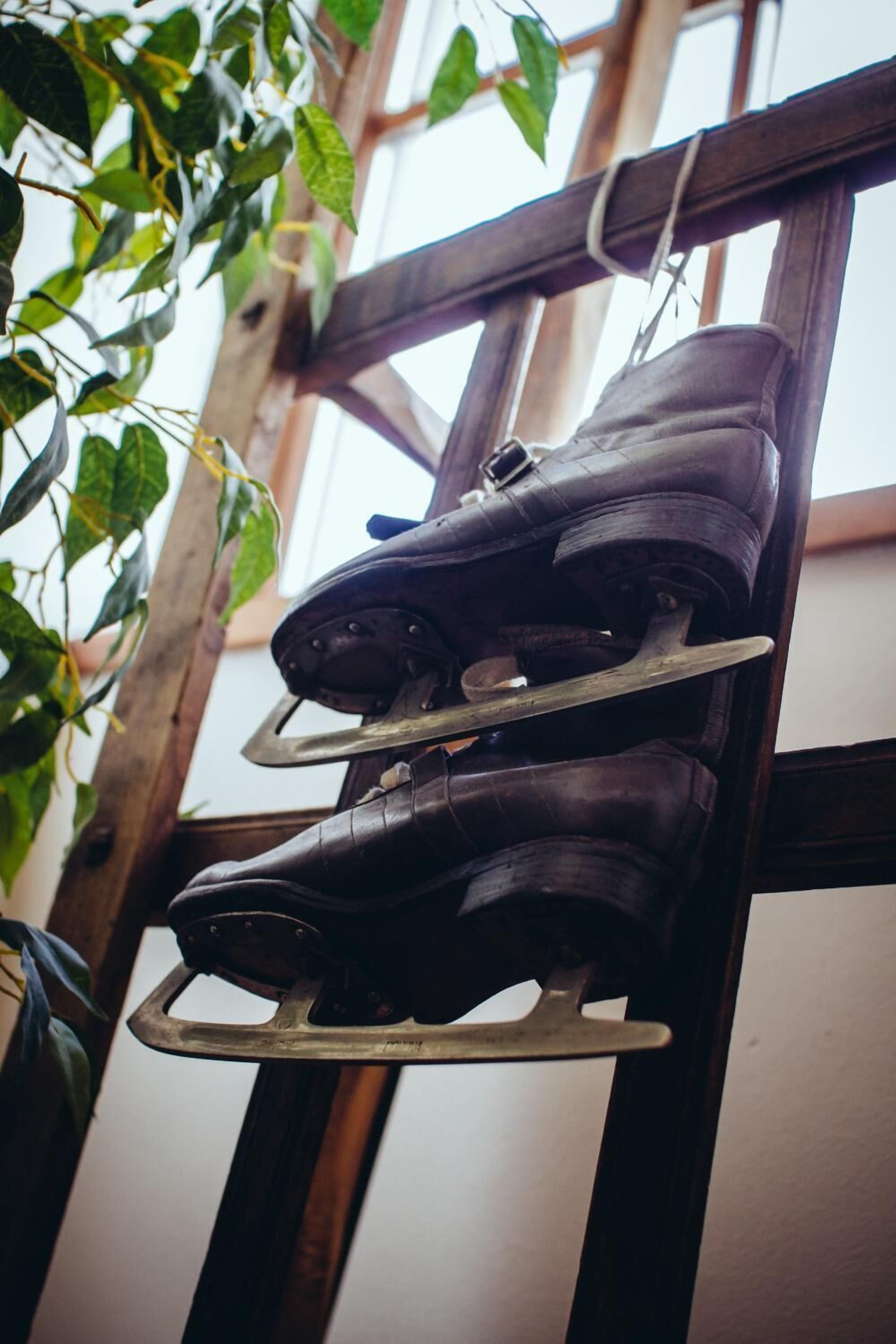 A pair of boots hanging on a wooden rack.
