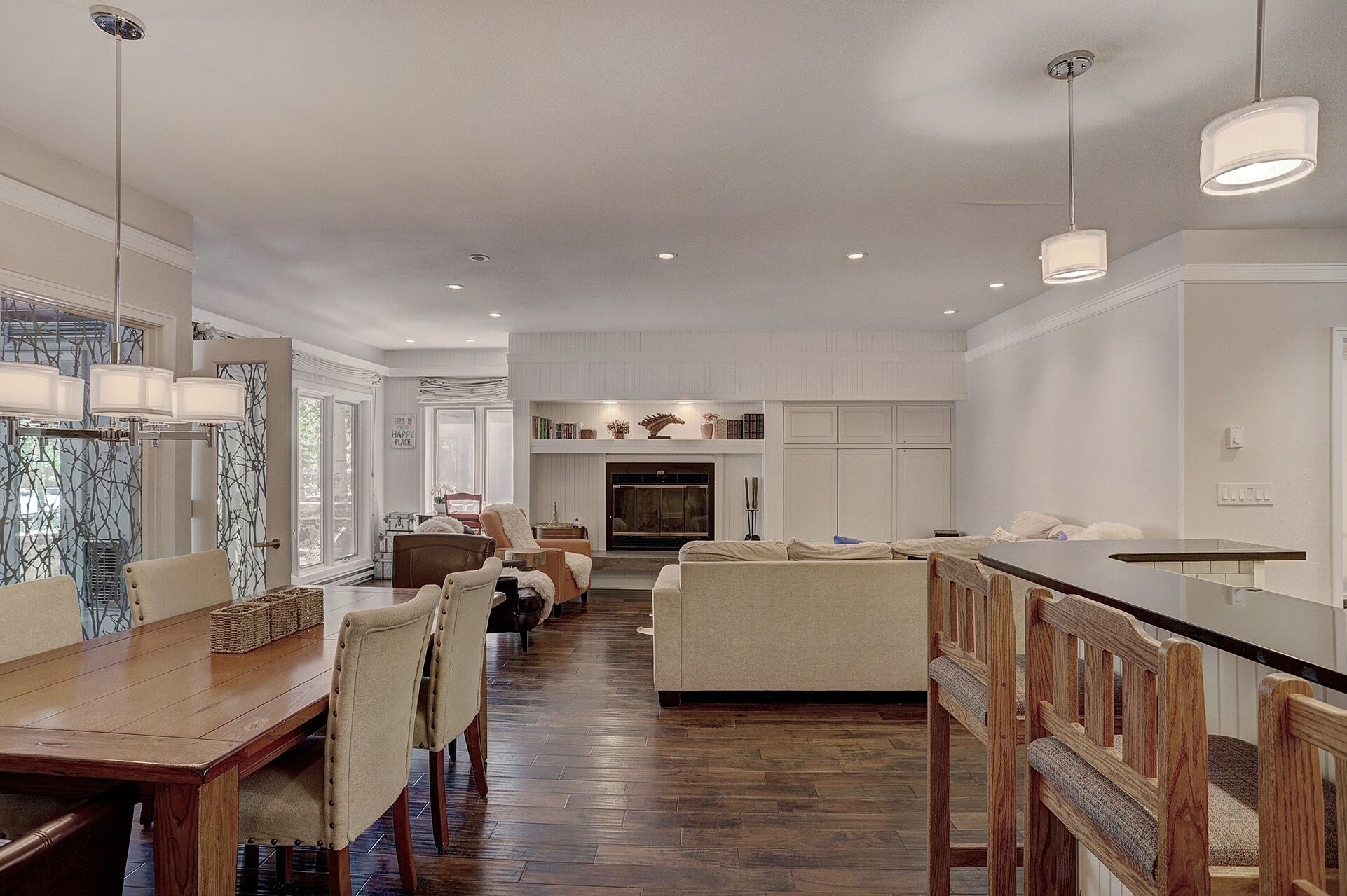 A spacious kitchen with a wooden dining table, chairs, and a bar area.