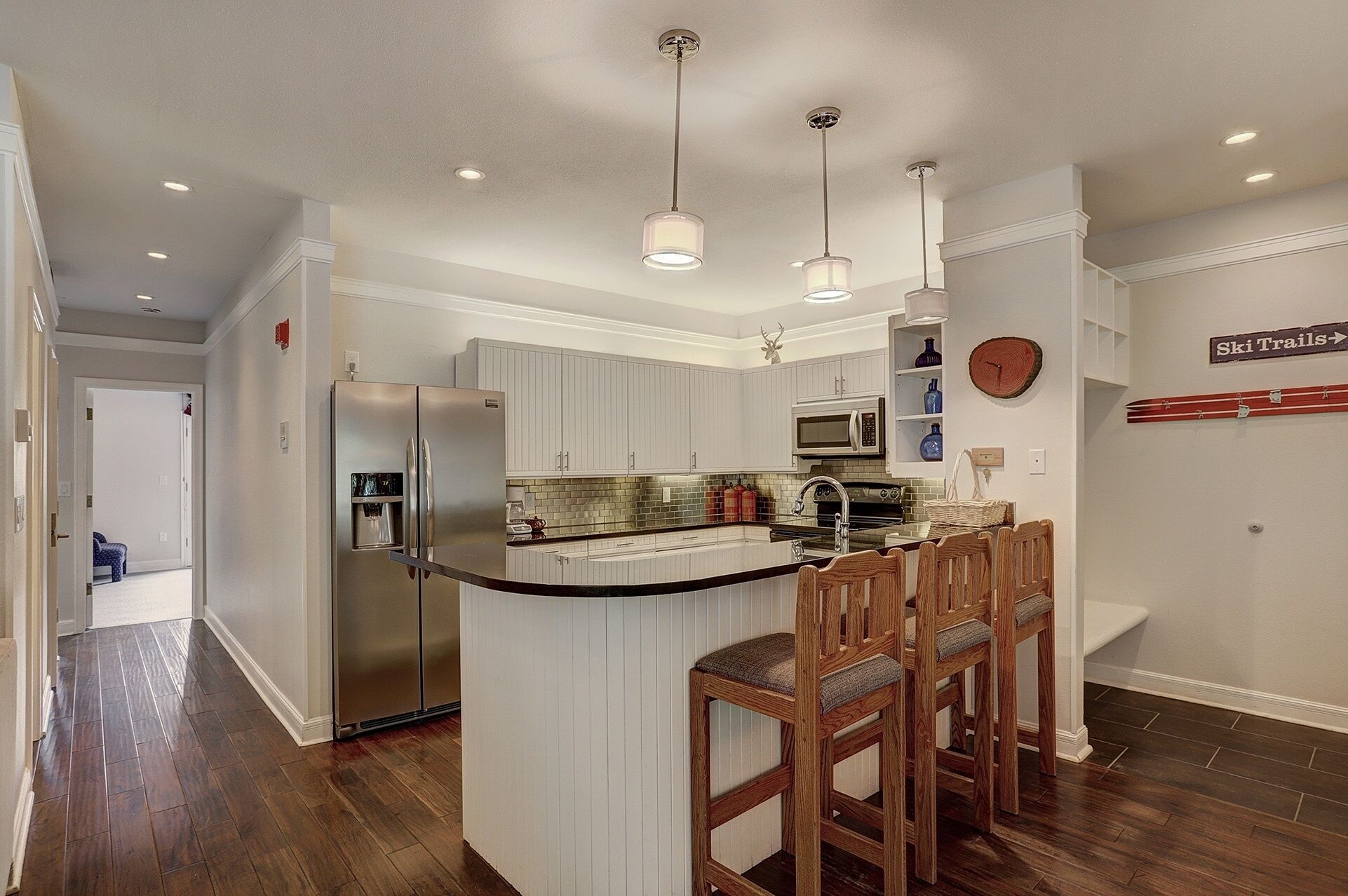 A modern kitchen with a central island, stainless steel appliances, and pendant lighting.
