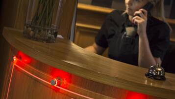 Ein Empfangstresen mit einem Schild, auf dem 'The Portland Reception' steht, und eine Vase mit Blumen.