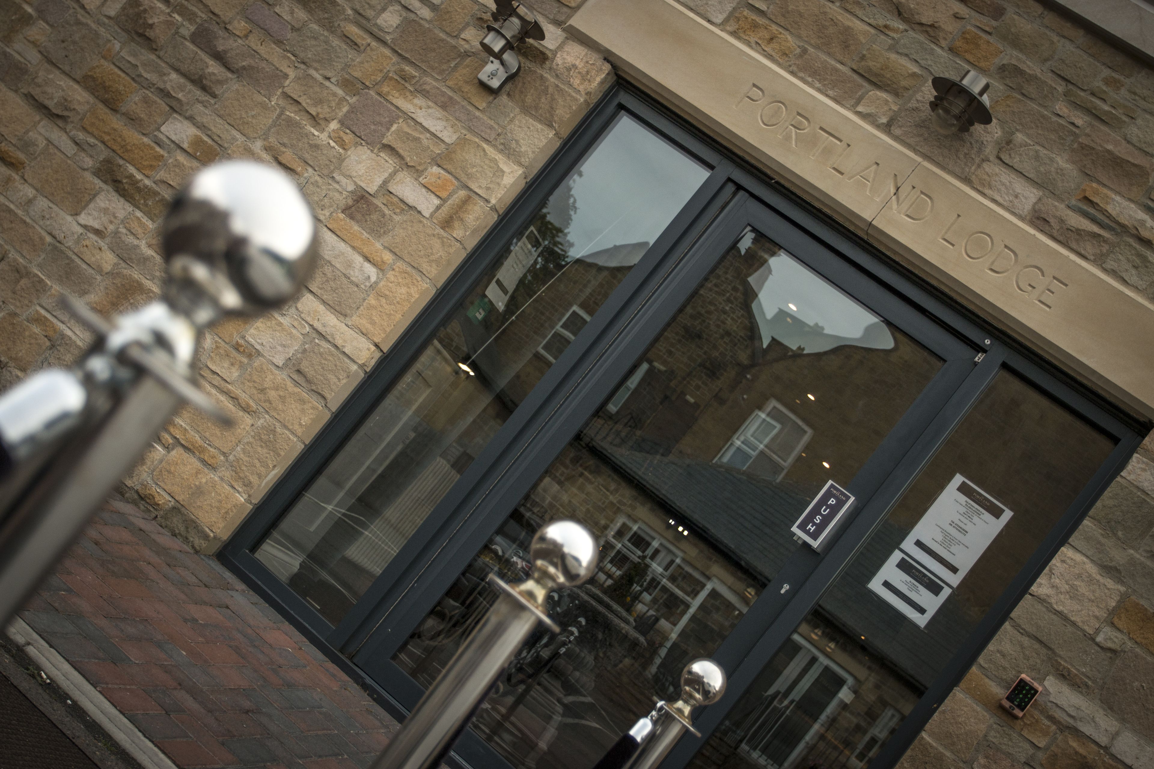 A building entrance with a stone facade and a sign reading "PORTLAND LODGE".