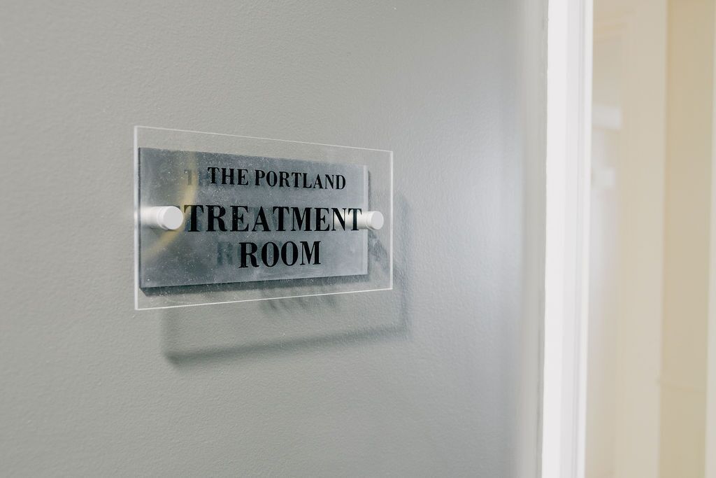 Een bord op een muur met de tekst 'The Portland Treatment Room'.