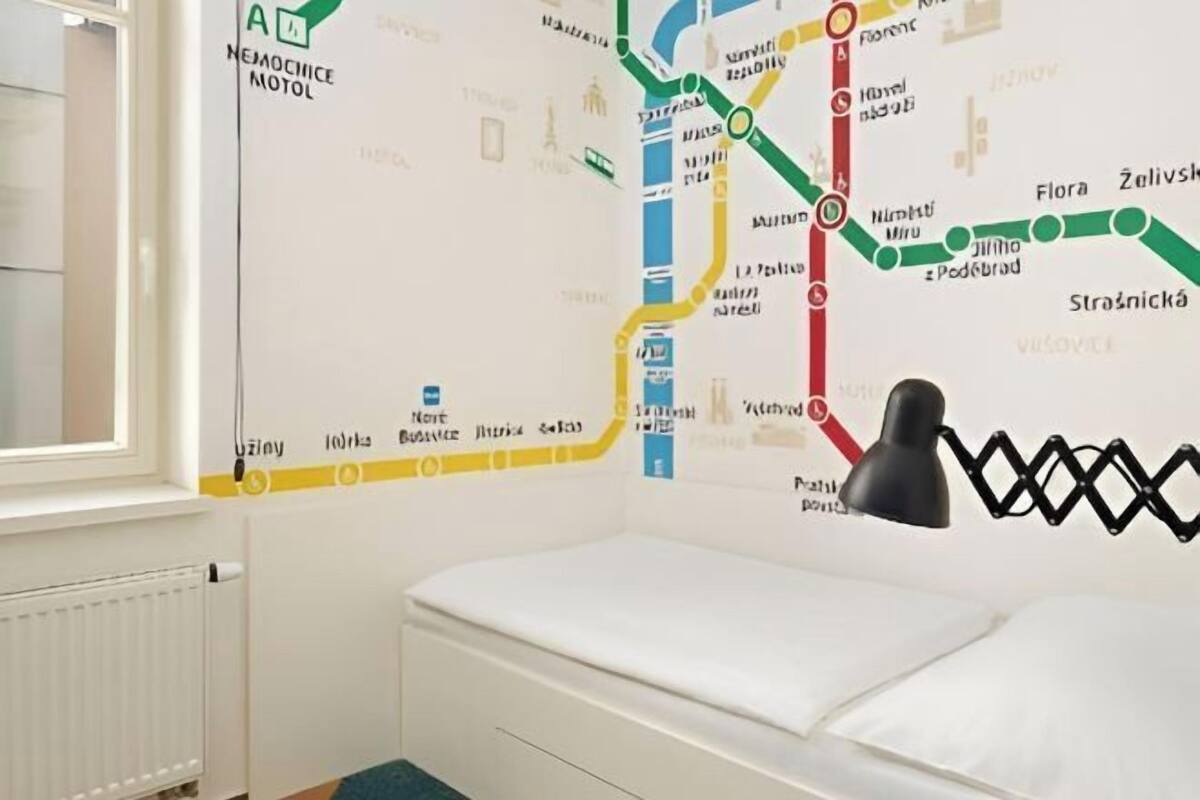 A room with a bed, a map on the wall, and a lamp.