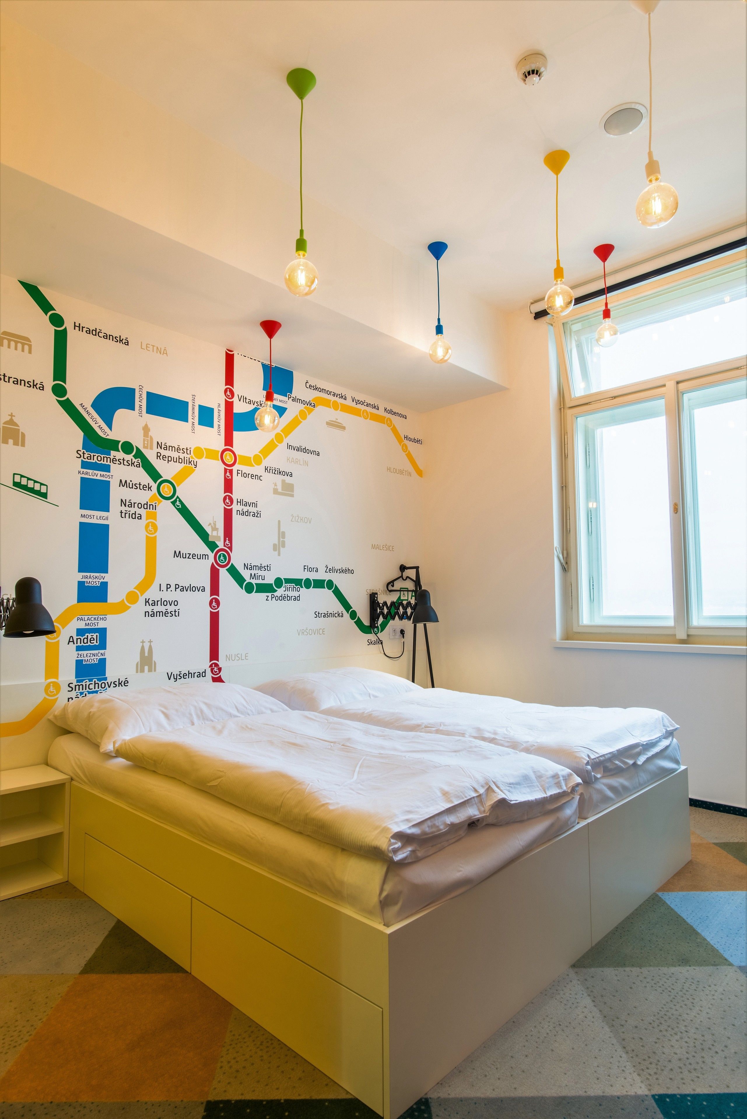 A bedroom with a bed, a map on the wall, and a window.