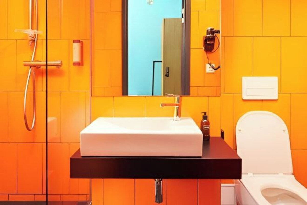 A bathroom with a white sink, a mirror, a shower, and a toilet.