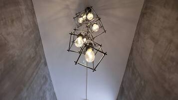 A modern ceiling light fixture with multiple bulbs, suspended from a geometric metal frame.