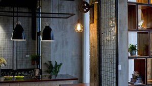 A modern interior with exposed brick walls, pendant lighting, and a wooden shelf with decorative items. - Zero Five One Seven Inn (Huangshan)