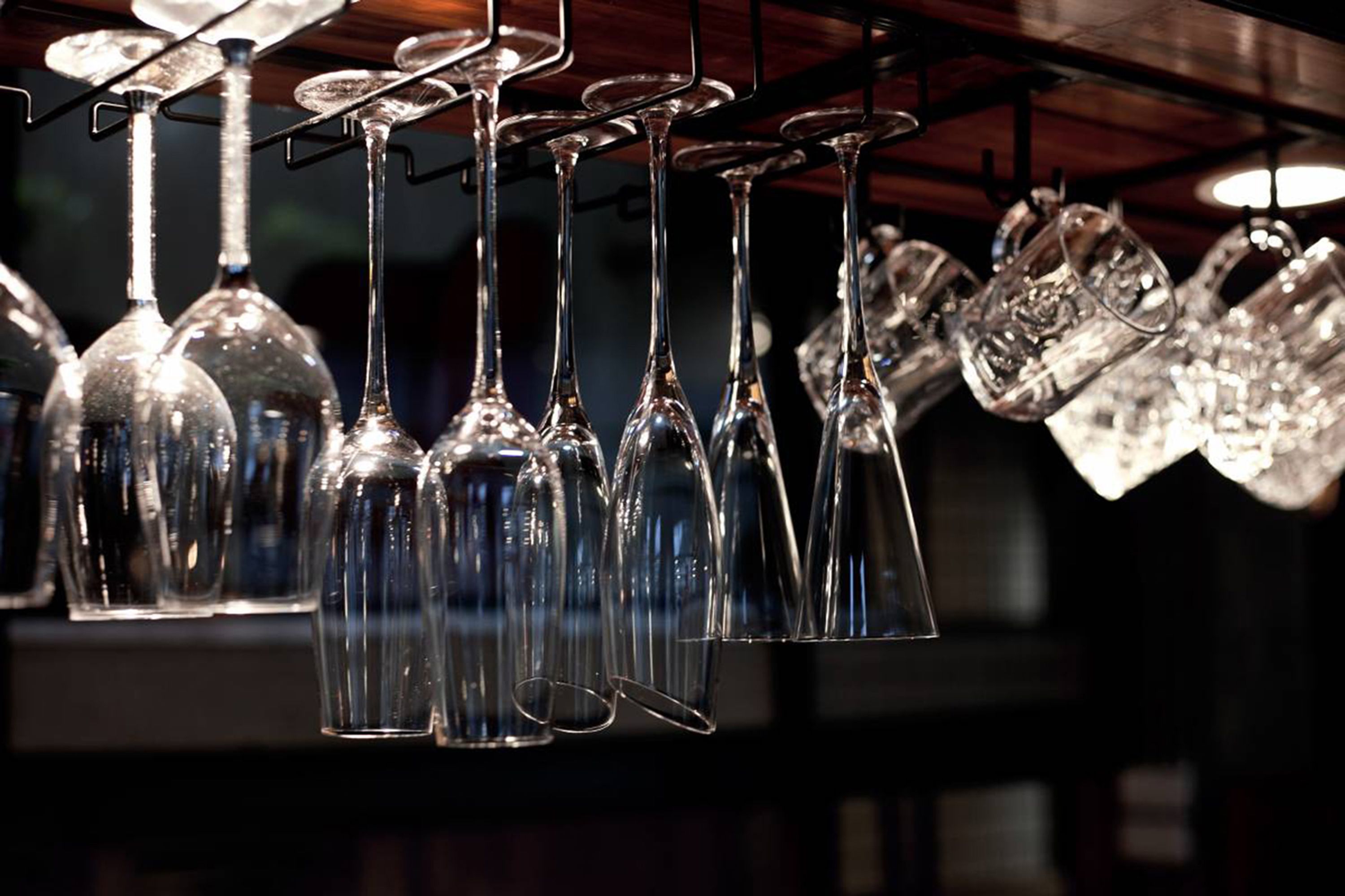 A collection of wine glasses hanging from a rack.