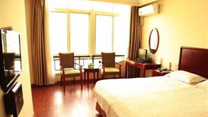 A hotel room with a bed, a desk with a chair, a TV, and a window with curtains. - GreenTree Inn Taizhou Xinghua Anfeng Runan Garden Express Hotel (Taizhou)