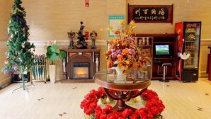 A lobby with a Christmas tree, a fireplace, a TV, and a vending machine. - GreenTree Inn Jiaxing Pinghu Zhapu Jiulong Mountain Express  Hotel (Jiaxing)