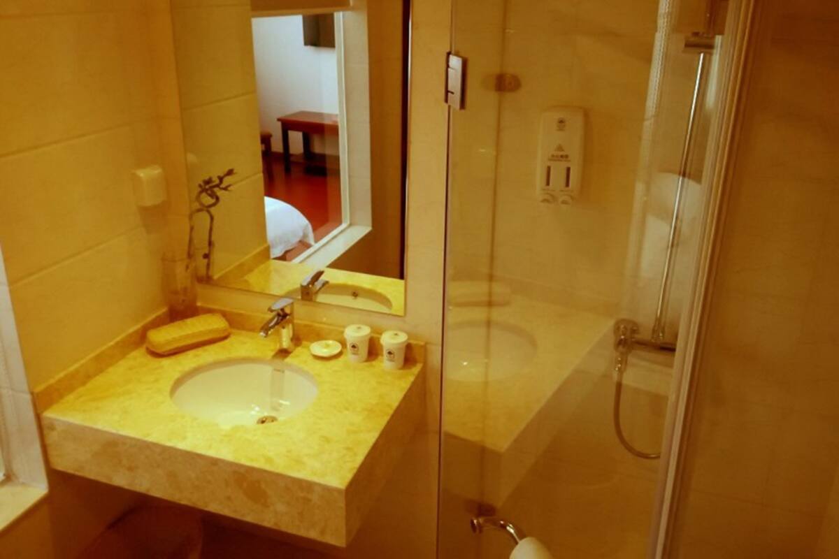 Un baño con lavamanos, espejo y cabina de ducha de vidrio.