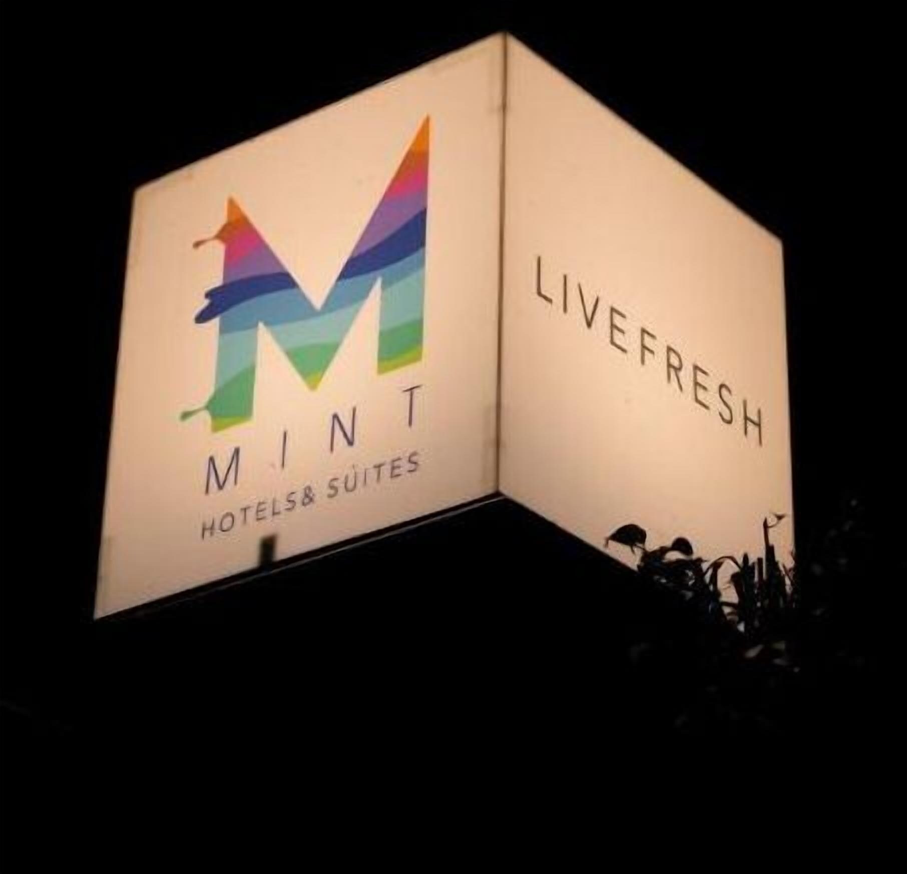 A hotel sign with a colorful 'M' logo and the words 'LIVEFRESH HOTELS& SUITES'.