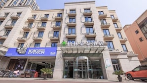 Et hotel med flere etager og moderne facade, med altaner på hver etage.