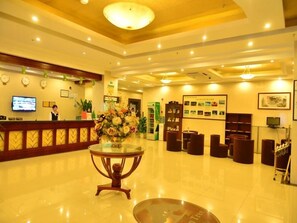 A hotel lobby with a reception desk, seating area, and a large decorative vase. - Greentree Inn Shanghai Jiading Dazhong International Auto City Business Hotel (Shanghai)