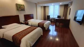A hotel room with two beds, a desk, a chair, a television, and a painting on the wall.