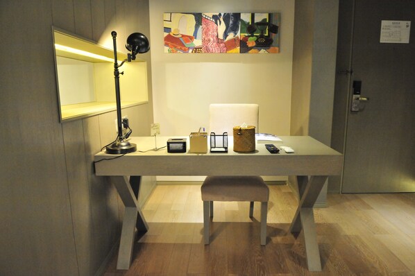 A modern office desk with a lamp, a computer, and a small chair.