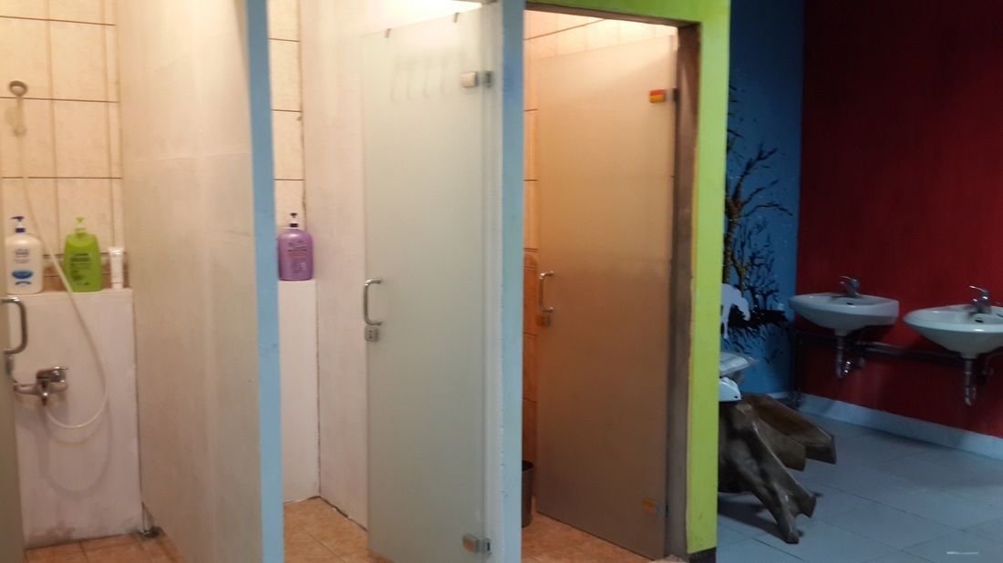 A bathroom with a shower, toilet, and two sinks.