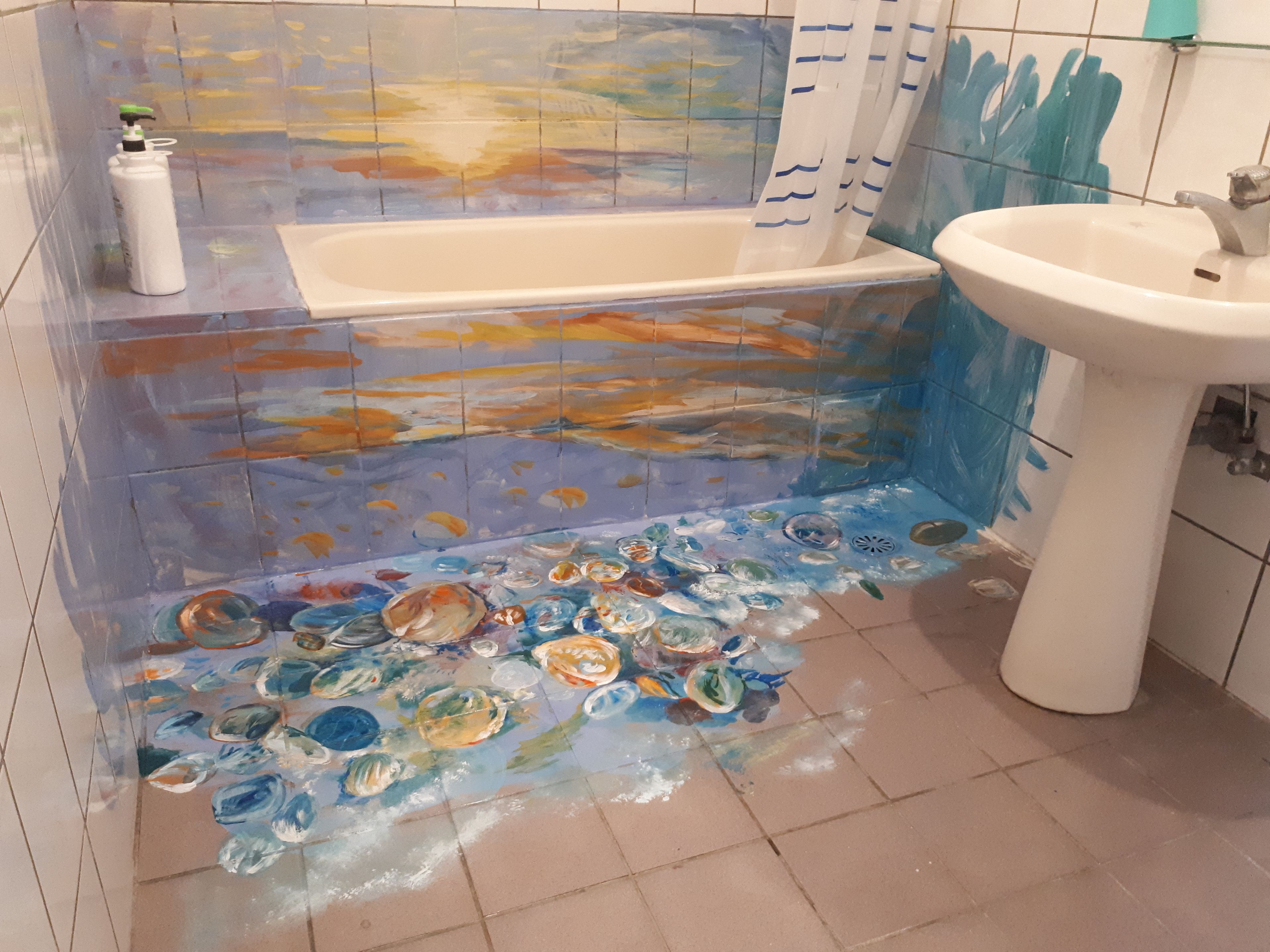 A bathroom with a bathtub, a sink, and a tiled floor with a painted design.
